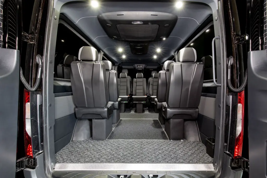 Mercedes-Benz Sprinter johon asennettu seitsemän lisä istuinta ja lattiamatto.