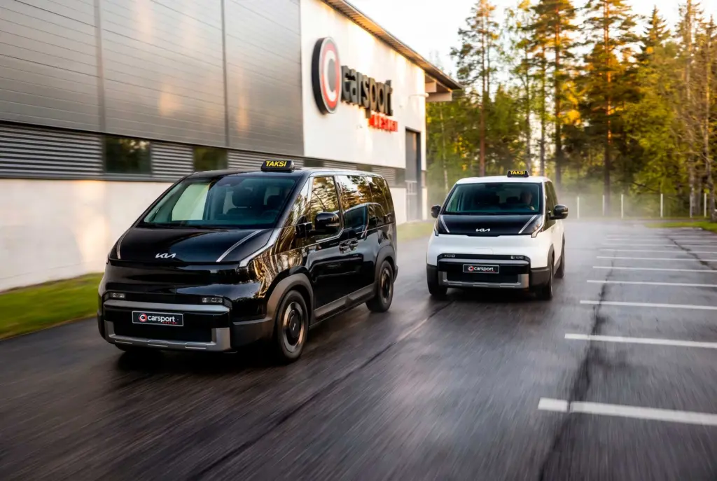 Musta ja valkoinen Kia PV5 ajossa Carsportin pihassa.
