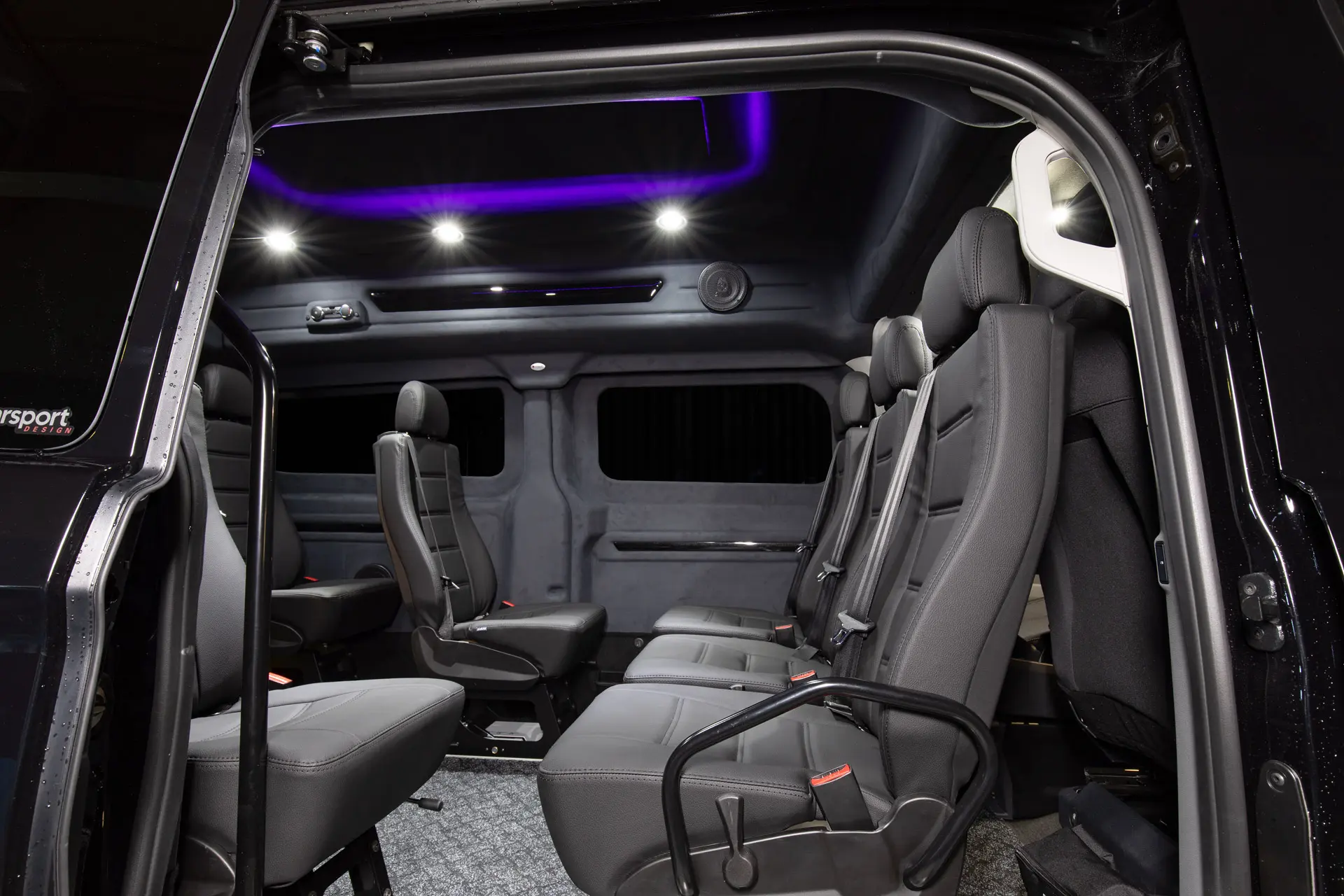 Näkymää liukuovelta Ford Customiin jossa täysin musta sisustus violetilla tunnelmavalaistuksella.